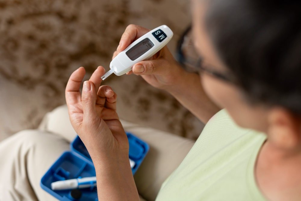 Rancho, California patient using a digital glucose meter at home for blood sugar testing.