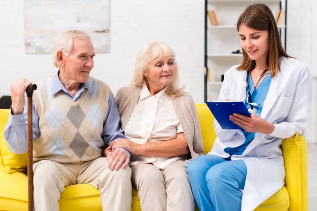 Rancho, California nurse sitting with an elderly man and woman on a sofa.